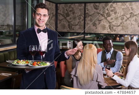 Polite waiter with serving tray Polite waiter with serving tray 47884657