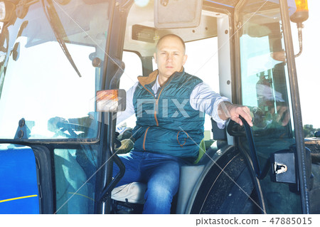 Man sitting in tractor cab 47885015