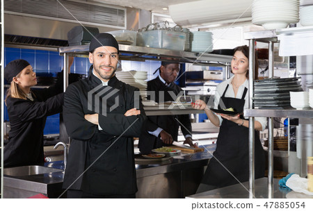 Smiling chef cook is posing on kitchen in restaurant. 47885054