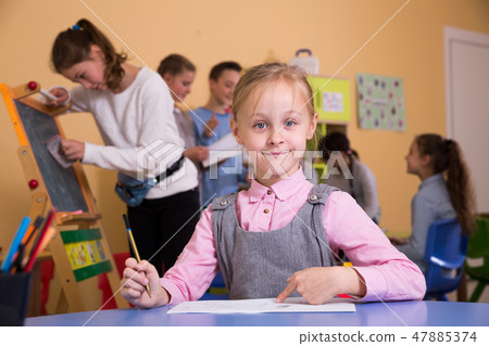 Happy little schoolgirl drawing during break Happy little schoolgirl drawing during break 47885374