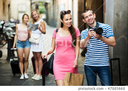 Couple walking with camera 47885668