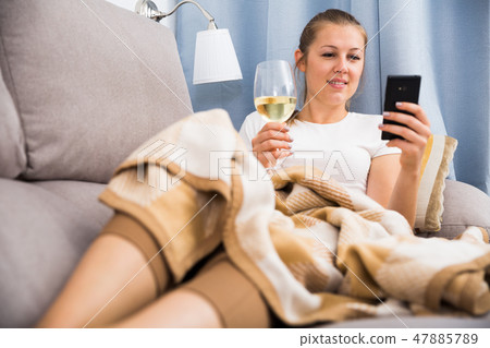 female with wine in glass using mobile phone female with wine in glass using mobile phone 47885789