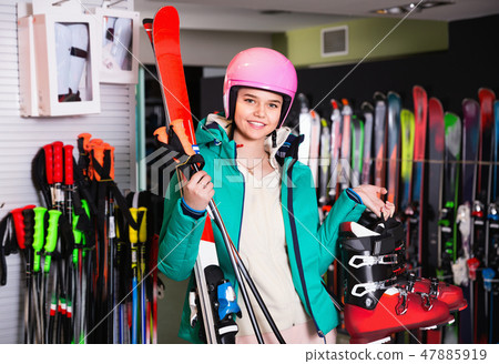 Woman standing with purchased ski equipment in shop Woman standing with purchased ski equipment in shop 47885919
