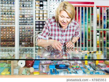 portrait of female cashier standing at cash desk in embroidery shop 47885951