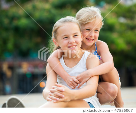 Two small happy sisters outdoors 47886067