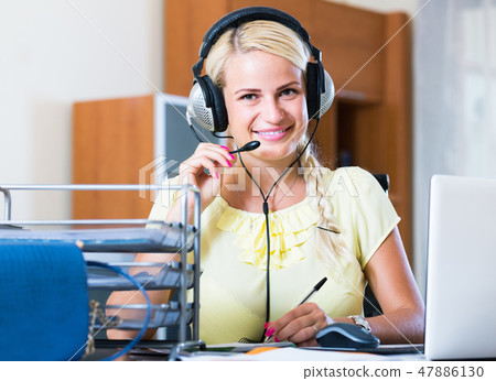 girl answering the call of technical support and smiling girl answering the call of technical support and smiling 47886130