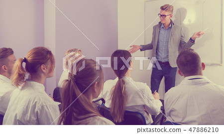 Positive male teacher lecturing to students Positive male teacher lecturing to students 47886210