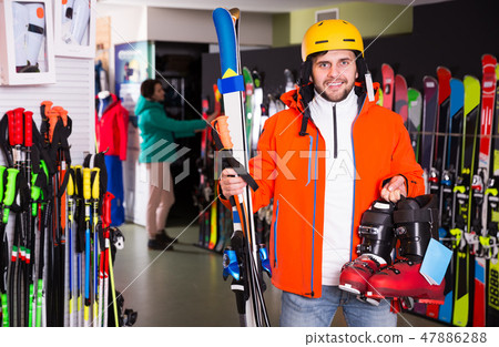 man standing with purchased ski equipment man standing with purchased ski equipment 47886288