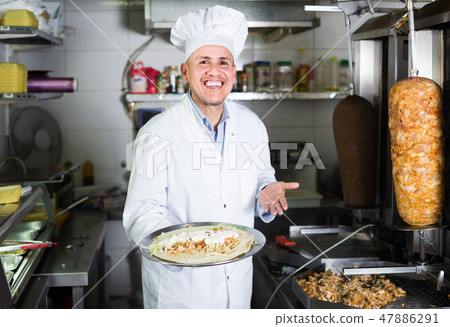 man cook making kebab dish on kitchen in fast food restaurant man cook making kebab dish on kitchen in fast food restaurant 47886291