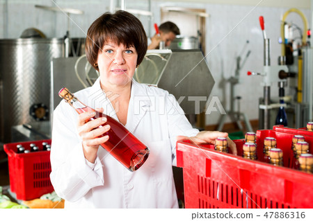 Female worker sorting wine bottles 47886316