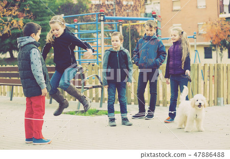Smiling children skipping on jumping rope Smiling children skipping on jumping rope 47886488