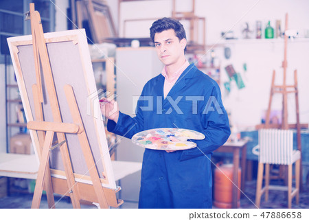 Man near easel painting on canvas Man near easel painting on canvas 47886658