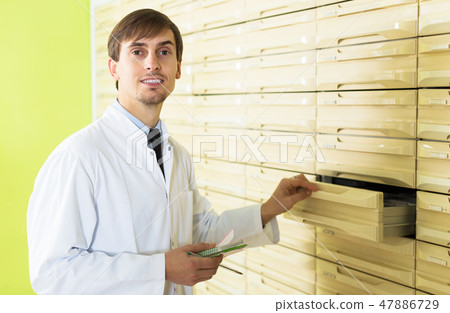 Pharmacist posing in pharmacy depot Pharmacist posing in pharmacy depot 47886729