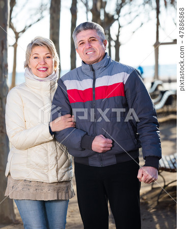 Smiling married couple walk in park Smiling married couple walk in park 47886868