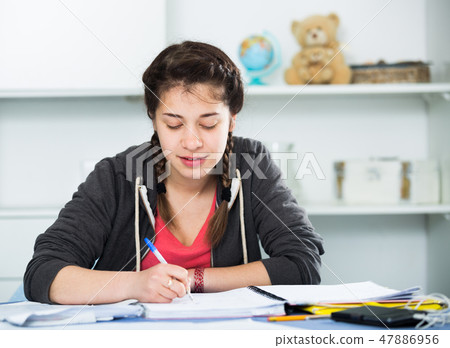 Girl doing homework Girl doing homework 47886956