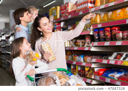parents with kids choosing biscuits 47887326
