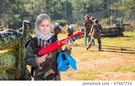 Portrait of joyful tween girl with marker gun Portrait of joyful tween girl with marker gun 47887718