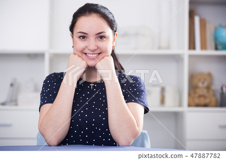 Young girl sitting at table Young girl sitting at table 47887782