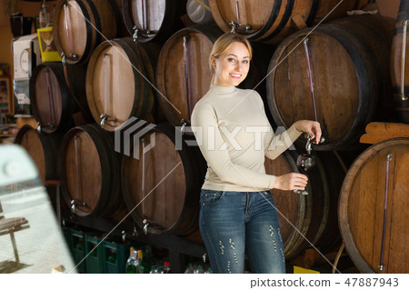 Woman selecting wine in wine house. 47887943