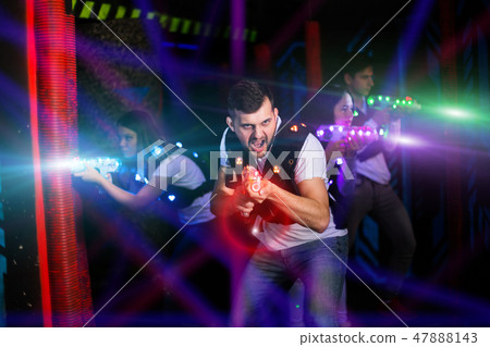 Excited guy laser tag player in bright beams 47888143