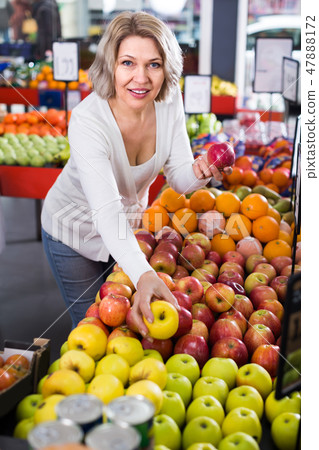 Woman selecting fruits in grocery . Woman selecting fruits in grocery . 47888172