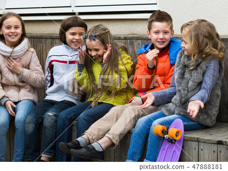 Kids whispering in other ears outdoor. 47888181
