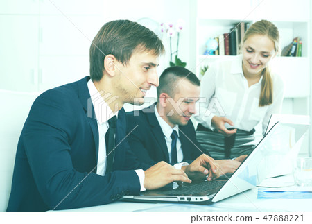 Business man sitting with laptop on desk 47888221