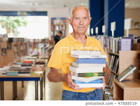 Portrait of positive aged man with stack of books in hands 47888519
