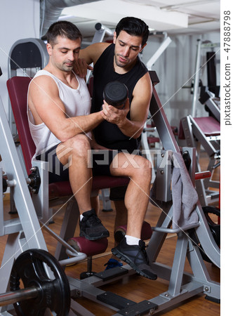 Guy with trainer in gym Guy with trainer in gym 47888798