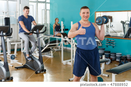 Sporty guy doing exercises with dumbbells Sporty guy doing exercises with dumbbells 47888932