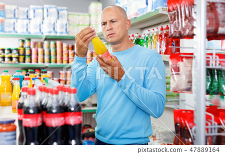 Focused man choosing fresh products during shopping at food store 47889164