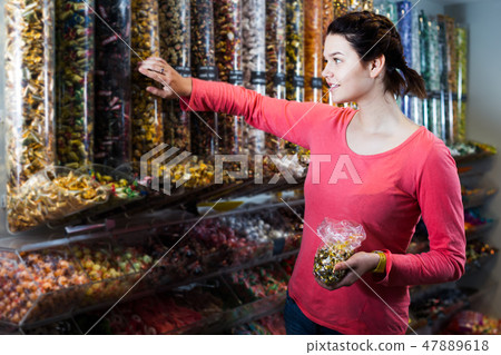 Girl choosing sweets in shop Girl choosing sweets in shop 47889618