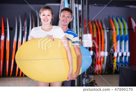 couple is posing in surfboard store on the beach. couple is posing in surfboard store on the beach. 47890170
