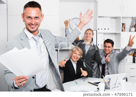 Smiling businessman and team delighted with achievements 47890171