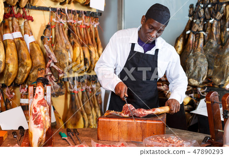 Nice seller cutting slices from leg of jamon Nice seller cutting slices from leg of jamon 47890293