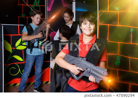 Portrait of teen boy standing with laser gun Portrait of teen boy standing with laser gun 47890294
