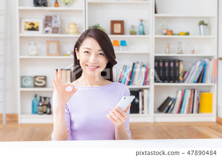 看智能手機的婦女在屋子裡 47890484