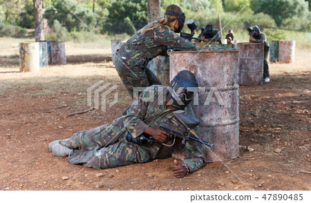 Paintball players of opposite teams in shootout Paintball players of opposite teams in shootout 47890485