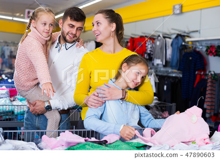 family with two girls choosing new clothes family with two girls choosing new clothes 47890603