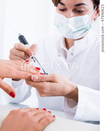 Woman doing shellac manicure Woman doing shellac manicure 47890625