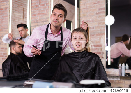 Man hairdresser discussing hairstyling with female client 47890626