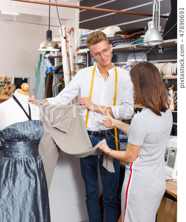 Tailor demonstrating client her order Tailor demonstrating client her order 47890691