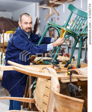 Carpenter repairing antique chair Carpenter repairing antique chair 47890734