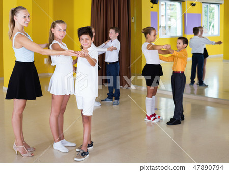 Little boys and girls having dancing class in classroom Little boys and girls having dancing class in classroom 47890794