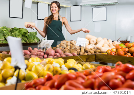 Young female seller holding yellow gourd 47891014