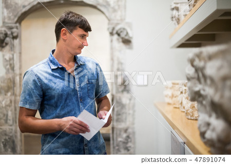 Man with information booklet in museum 47891074