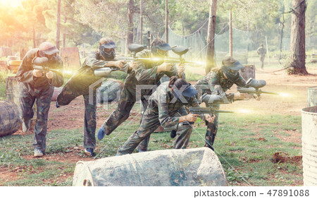 Portrait of team of adult people playing on paintball battlefiel Portrait of team of adult people playing on paintball battlefiel 47891088