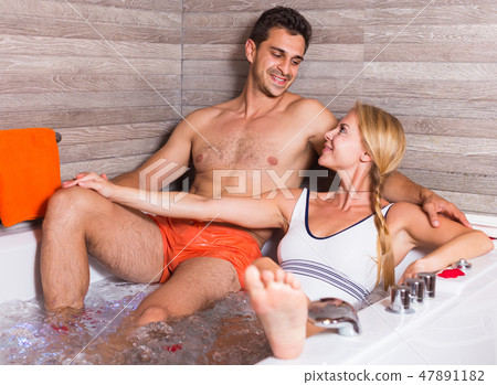 Man with woman are relaxing in jacuzzi with petals of roses 47891182