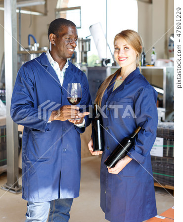 Winemakers checking wine in glass Winemakers checking wine in glass 47891229