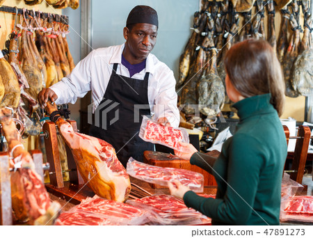 Salesman selling jamon to woman Salesman selling jamon to woman 47891273